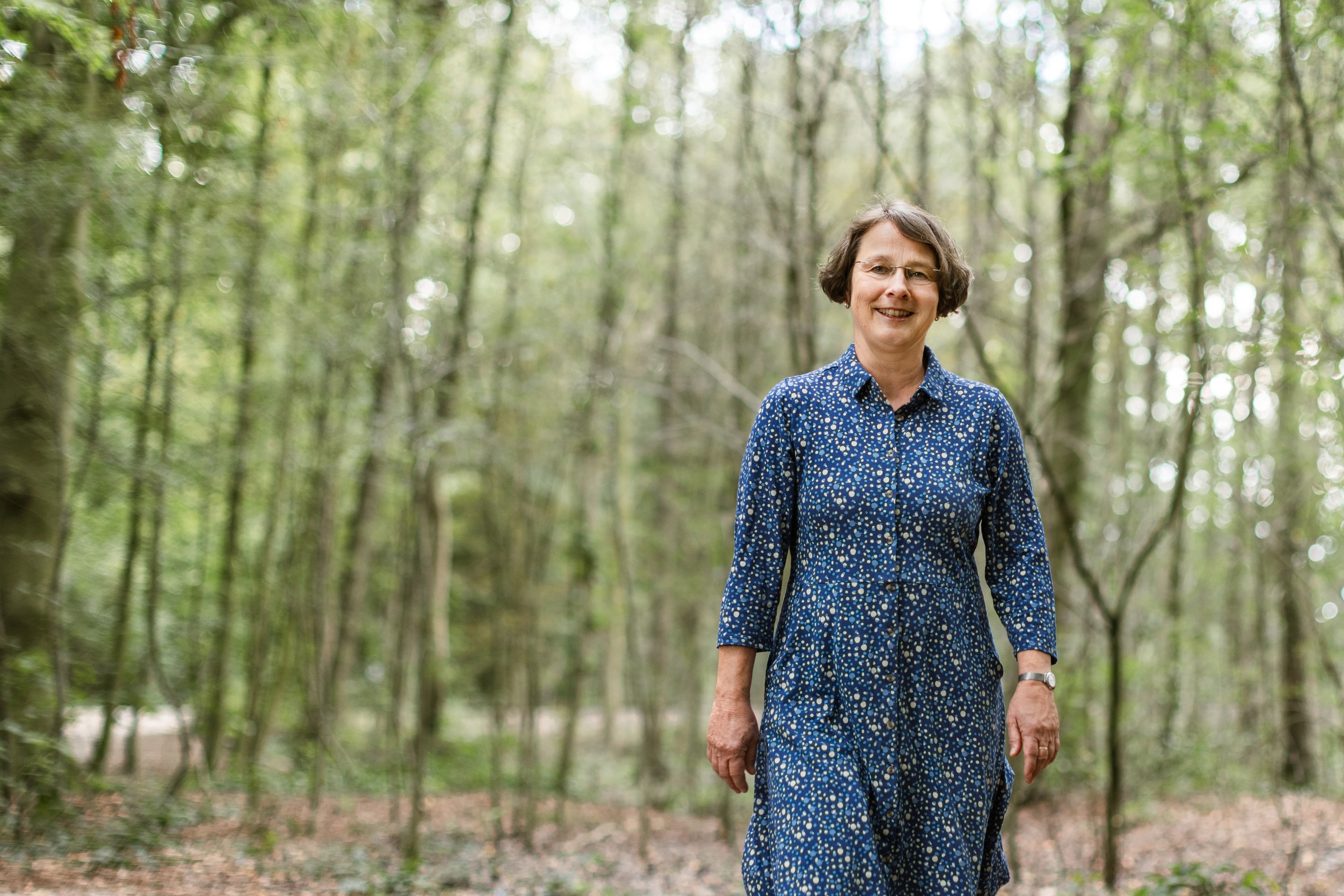 Frau in blauem Kleid im Wald